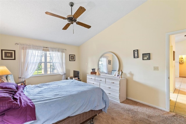 carpeted bedroom with a ceiling fan, vaulted ceiling, a textured ceiling, and baseboards