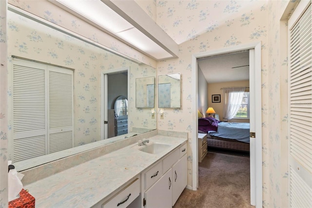 bathroom featuring a closet, ensuite bath, vanity, and wallpapered walls
