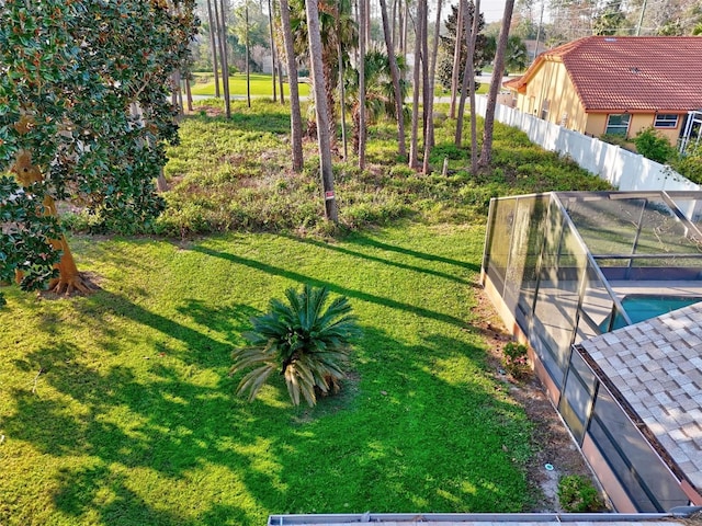 view of yard with a lanai, fence, and a fenced in pool