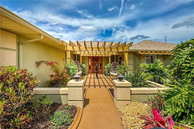 property entrance with a pergola and stucco siding