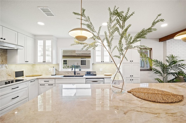 kitchen with visible vents, glass insert cabinets, light stone countertops, white cabinetry, and a sink