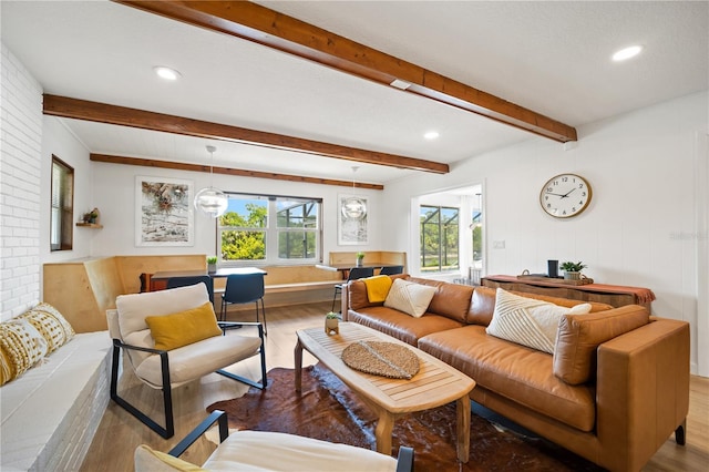 living area featuring light wood-style floors, recessed lighting, and beamed ceiling