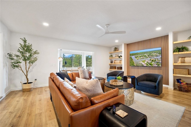 living room with recessed lighting, light wood-type flooring, a ceiling fan, and baseboards