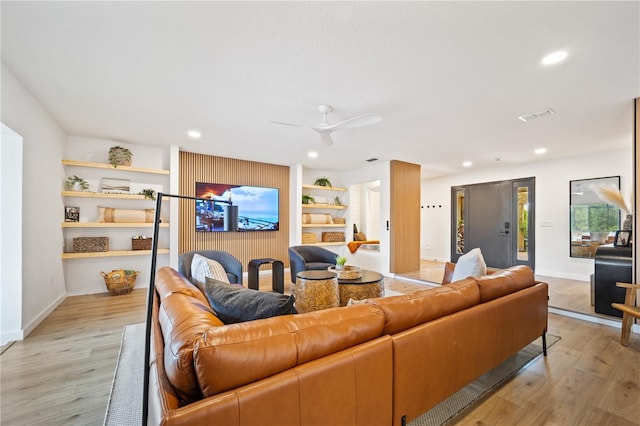 living area with visible vents, recessed lighting, light wood-style flooring, and built in features