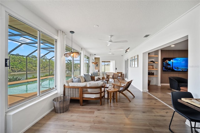 sunroom featuring visible vents and a ceiling fan