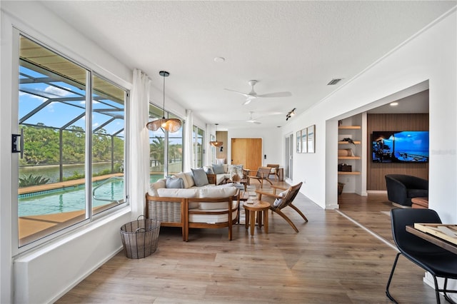 sunroom with a ceiling fan and visible vents