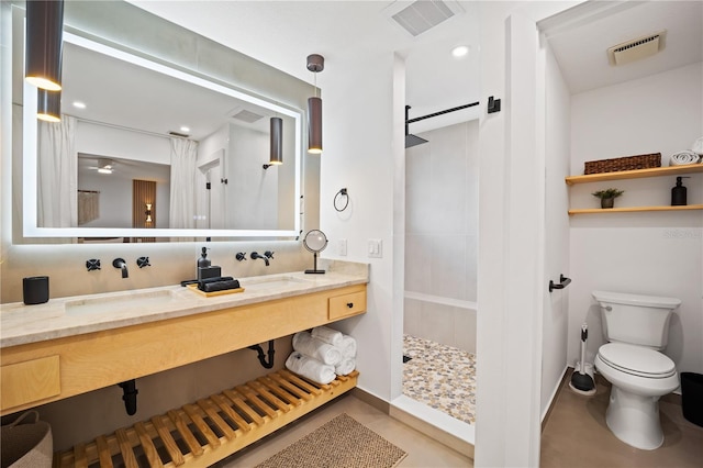 bathroom featuring visible vents, a sink, toilet, and walk in shower