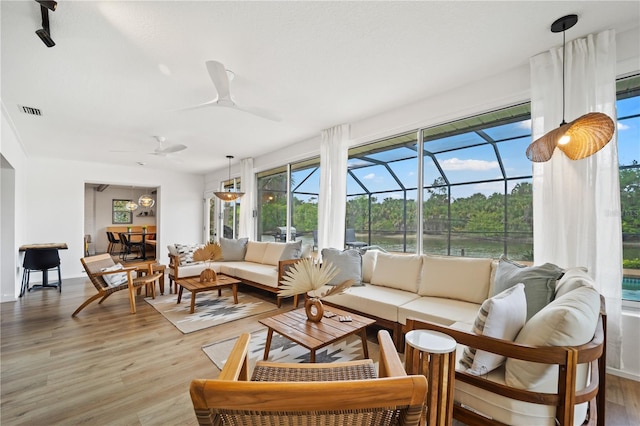 sunroom with ceiling fan and visible vents