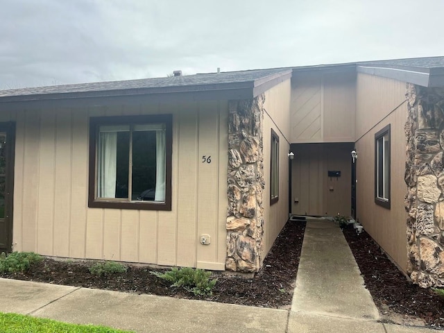 view of side of property with roof with shingles