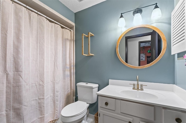 bathroom featuring toilet, a textured ceiling, and vanity