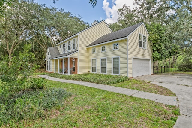 view of front of property with a front yard, fence, driveway, and an attached garage