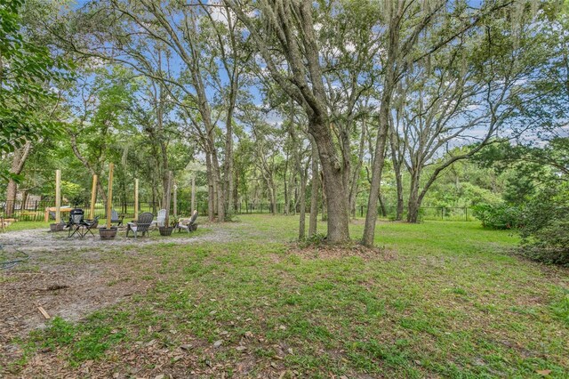 view of yard featuring an outdoor fire pit and fence