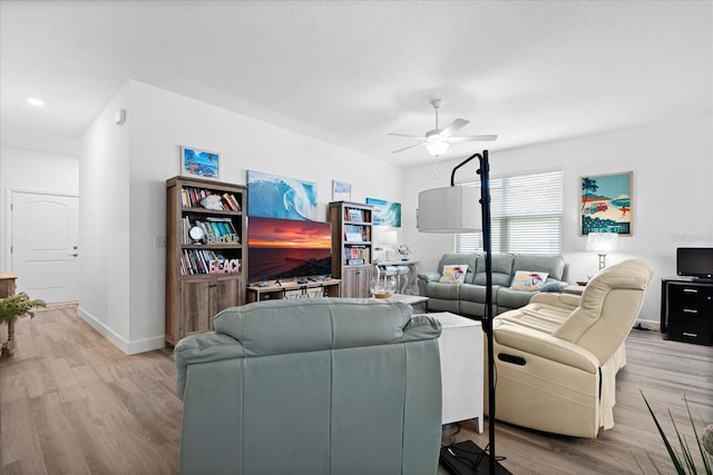 living area featuring ceiling fan, a textured ceiling, wood finished floors, and baseboards