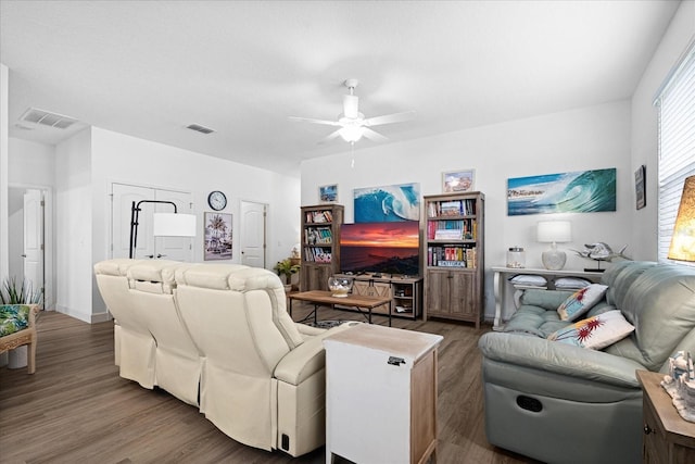 living room with a ceiling fan, visible vents, and wood finished floors