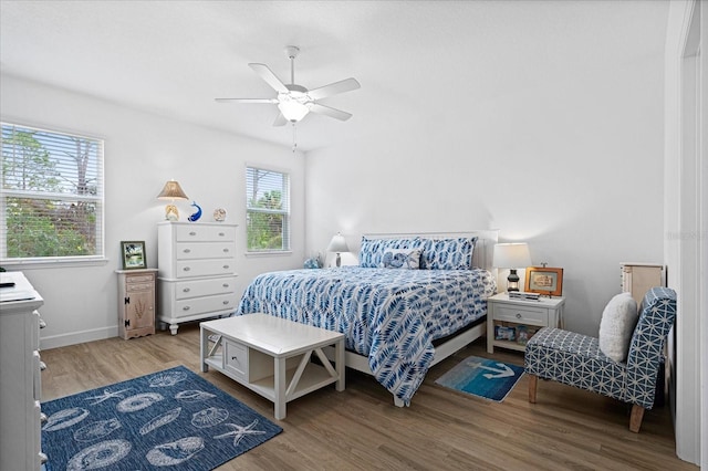 bedroom featuring ceiling fan, baseboards, and wood finished floors