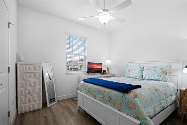 bedroom featuring wood finished floors, a ceiling fan, and baseboards