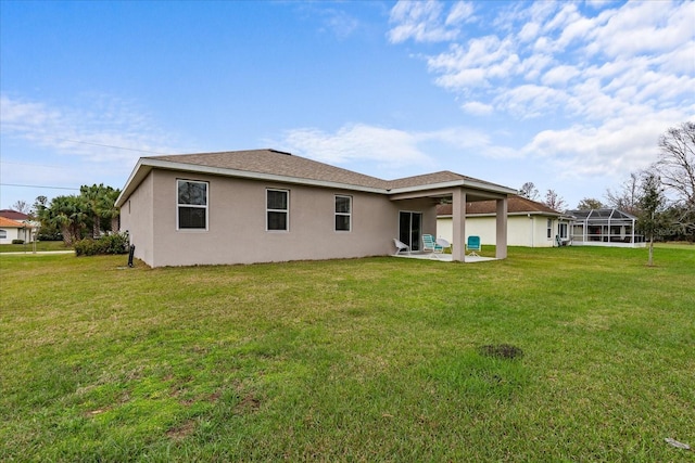 back of property featuring a patio, a lawn, and stucco siding