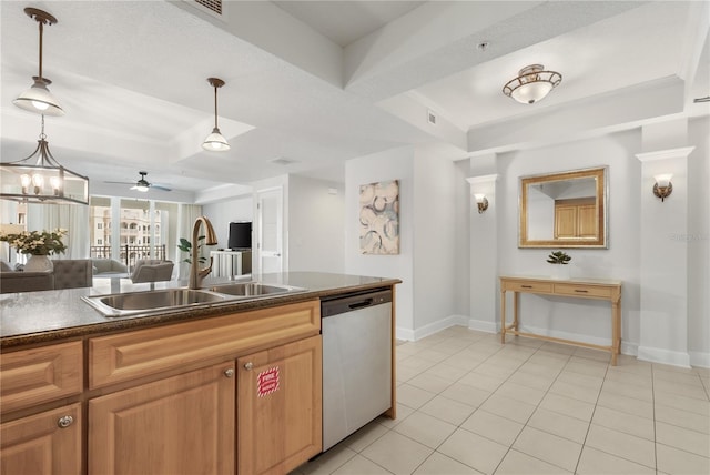 kitchen with light tile patterned floors, dark countertops, a raised ceiling, stainless steel dishwasher, and a sink