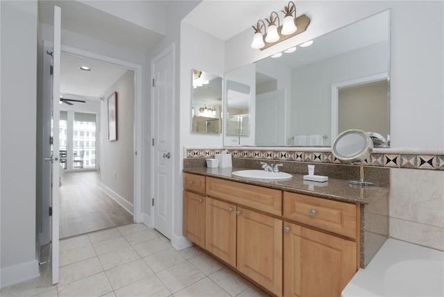 bathroom featuring a tub to relax in, vanity, a ceiling fan, and tile patterned floors