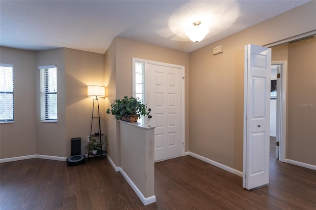 foyer entrance with wood finished floors and baseboards