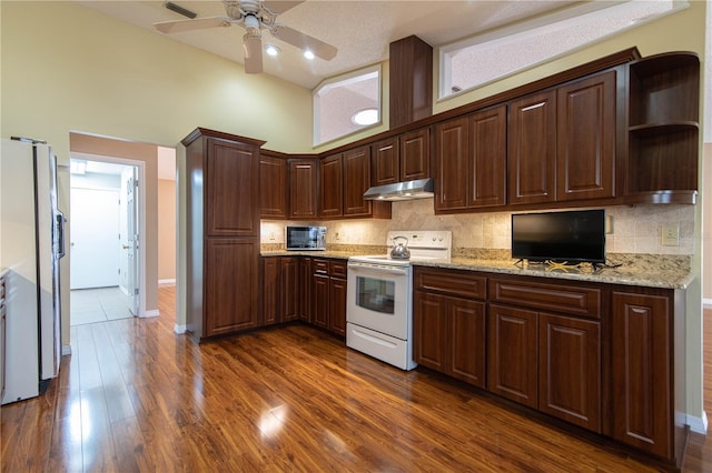 kitchen featuring white electric range oven, dark wood finished floors, freestanding refrigerator, under cabinet range hood, and backsplash