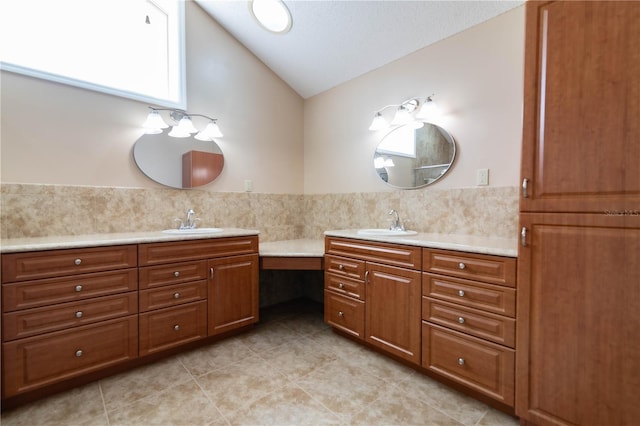 bathroom with vaulted ceiling, vanity, and tile patterned floors