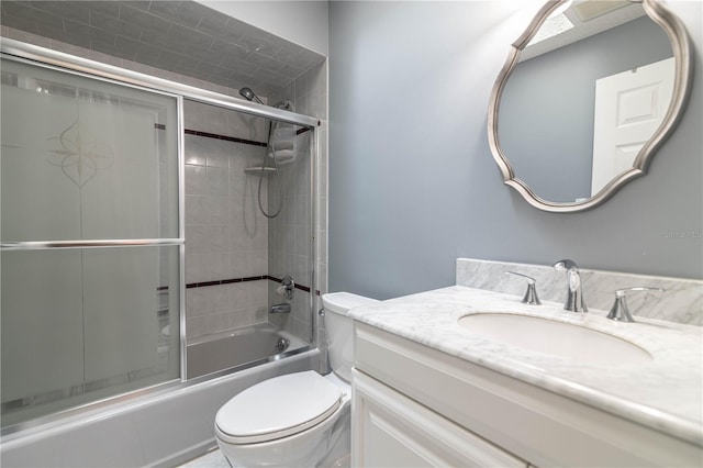 bathroom with toilet, shower / bath combination with glass door, and vanity