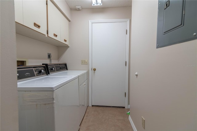 washroom featuring light tile patterned floors, cabinet space, a textured ceiling, electric panel, and independent washer and dryer