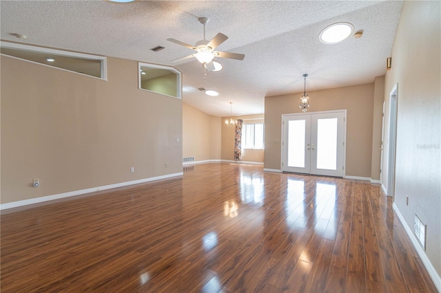 spare room with french doors, visible vents, dark wood-style flooring, and ceiling fan with notable chandelier