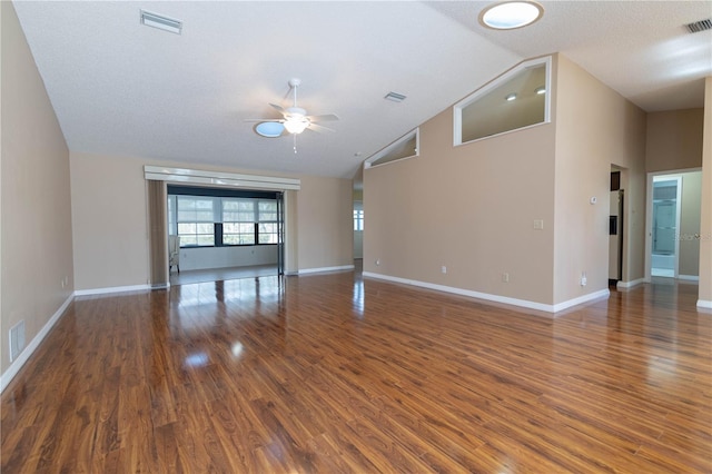 unfurnished living room with visible vents, dark wood-type flooring, a ceiling fan, high vaulted ceiling, and baseboards