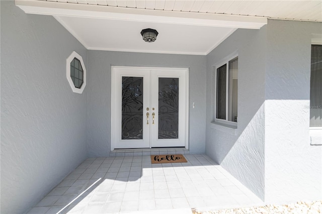 view of exterior entry with french doors, a patio area, and stucco siding