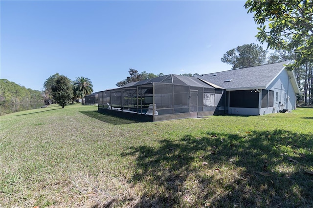 exterior space featuring glass enclosure and a yard