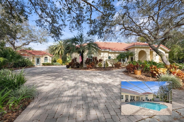 view of front facade featuring an outdoor pool, a tiled roof, and stucco siding