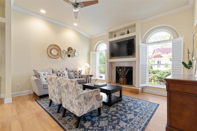 living area with crown molding, recessed lighting, a premium fireplace, light wood-type flooring, and baseboards