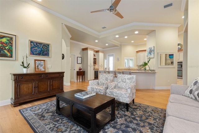 living area with visible vents, light wood-style flooring, and baseboards