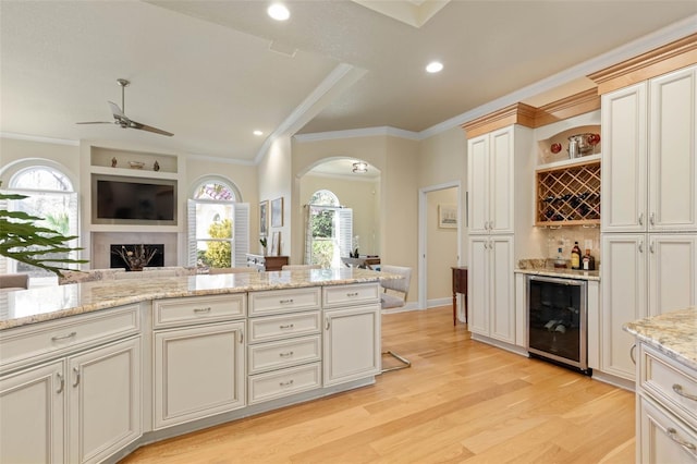 kitchen with plenty of natural light, wine cooler, arched walkways, and open floor plan