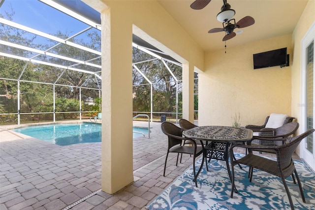 outdoor pool with a lanai, a ceiling fan, and a patio