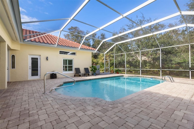 outdoor pool featuring a patio and glass enclosure