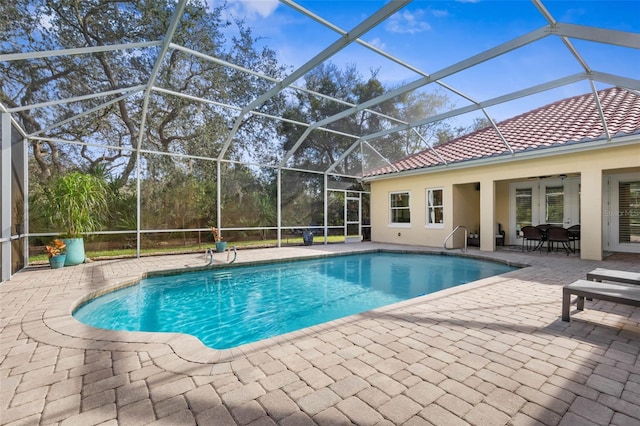 outdoor pool with glass enclosure and a patio area