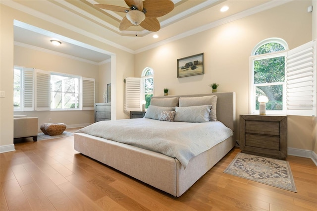 bedroom featuring recessed lighting, wood finished floors, baseboards, ornamental molding, and a raised ceiling