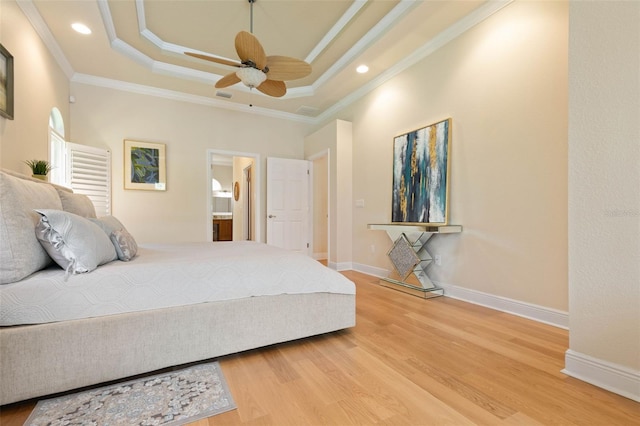 bedroom with baseboards, visible vents, ornamental molding, wood finished floors, and a tray ceiling