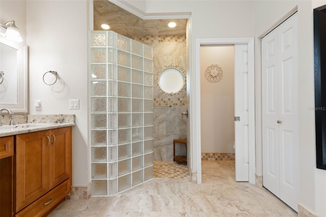 bathroom featuring walk in shower and vanity