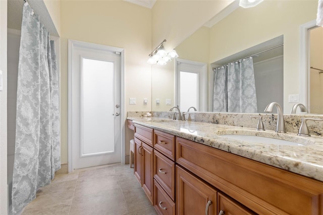 full bath featuring double vanity, curtained shower, tile patterned flooring, and a sink