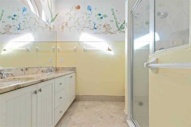 bathroom featuring double vanity, a stall shower, a sink, and tile patterned floors