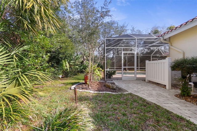 view of yard with glass enclosure and an outdoor pool