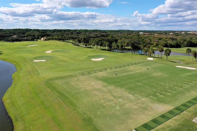 drone / aerial view with view of golf course and a water view