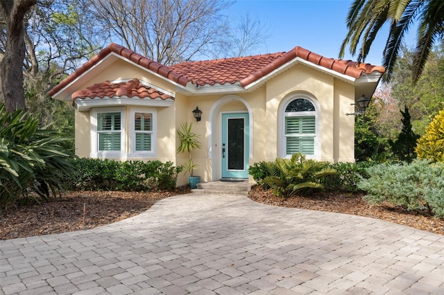 mediterranean / spanish-style home with a tiled roof and stucco siding