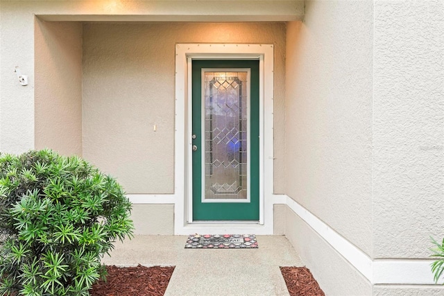 property entrance with stucco siding