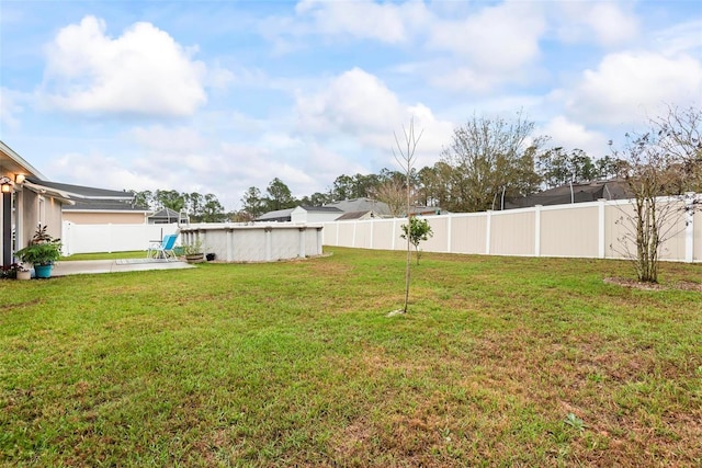 view of yard featuring a patio area, a fenced backyard, and an outdoor pool