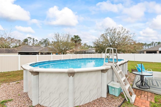 view of swimming pool with a fenced backyard, a lawn, and a fenced in pool